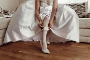bride-in-silk-robe-putting-on-stockings-wedding-morning-preparation-concept.jpg