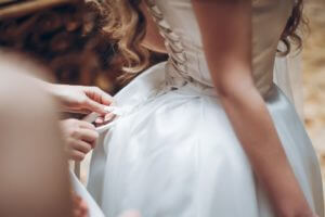 bridesmaids-dressing-bride-in-the-morning-in-hotel-room.jpg